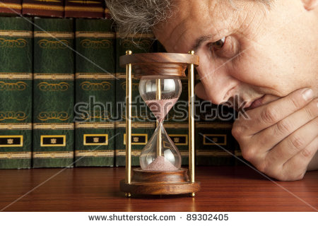 stock-photo-man-looking-at-hourglass-89302405.jpg