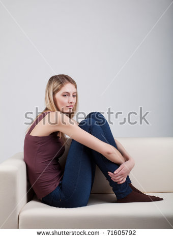 stock-photo-girl-sitting-on-the-sofa-hugging-his-arms-legs-71605792.jpg