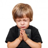 16028601-little-boy-praying-with-the-bible-in-hand.jpg