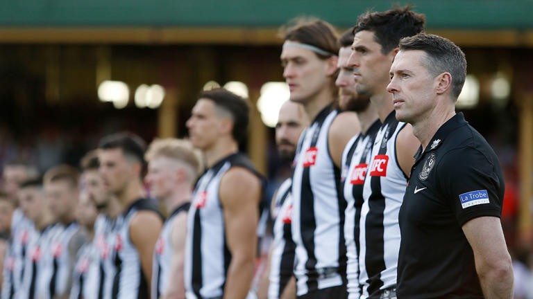 Collingwood coach [PLAYERCARD]Craig McRae[/PLAYERCARD] stands with his team for the national anthem.