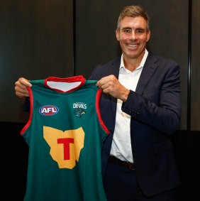 Tasmanian football great [PLAYERCARD]Matthew Richardson[/PLAYERCARD] poses with the Devils’ first AFL jumper.