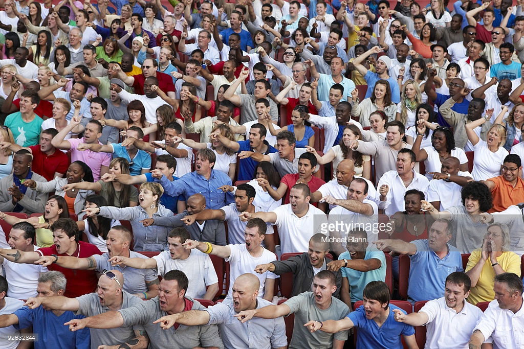 crowd-of-people-pointing-and-shouting-in-stadium-picture-id92632844