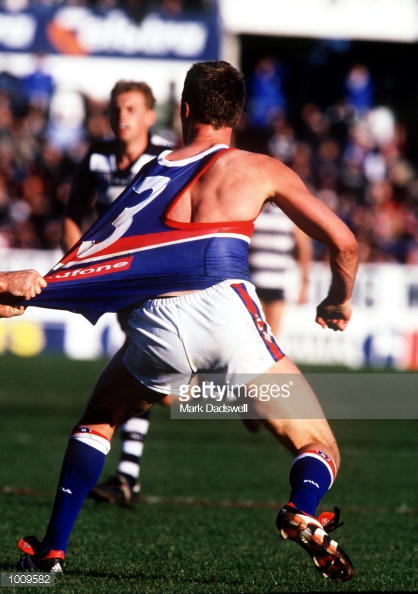 jul-1999-chris-grant-for-the-western-bulldogs-is-tackled-by-a-geelong-picture-id1009582