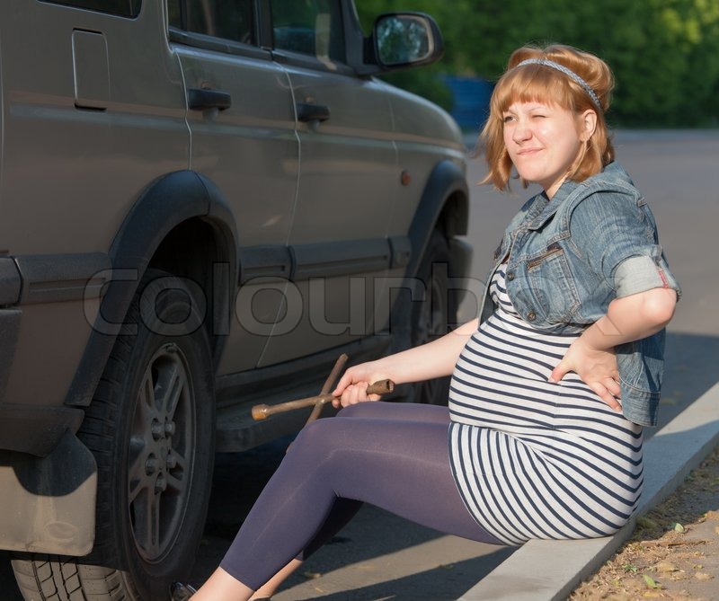 4151346-274208-pregnant-woman-with-a-wheel-brace-near-car.jpg