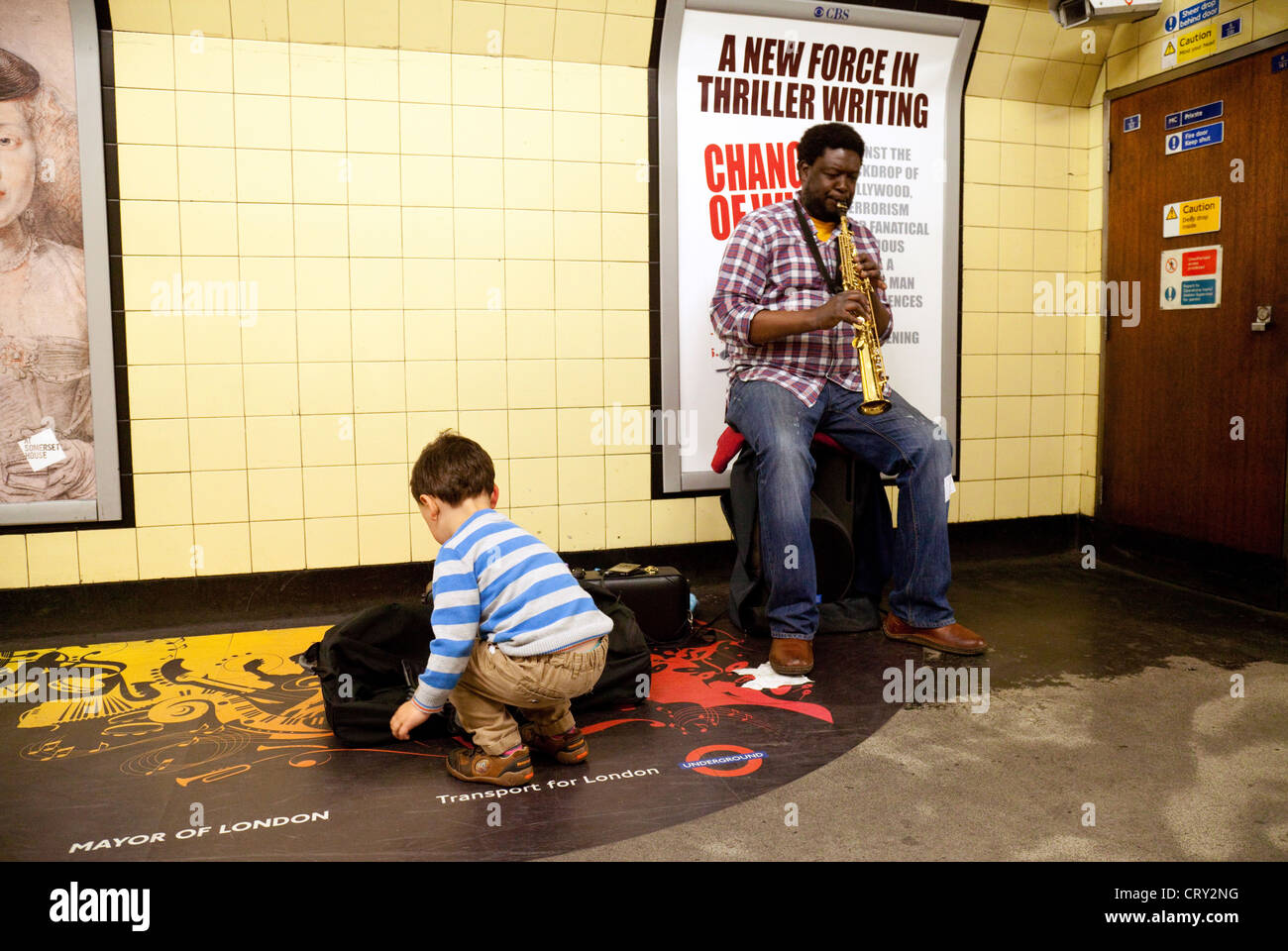 a-child-giving-money-to-a-busker-on-the-london-underground-playing-CRY2NG.jpg