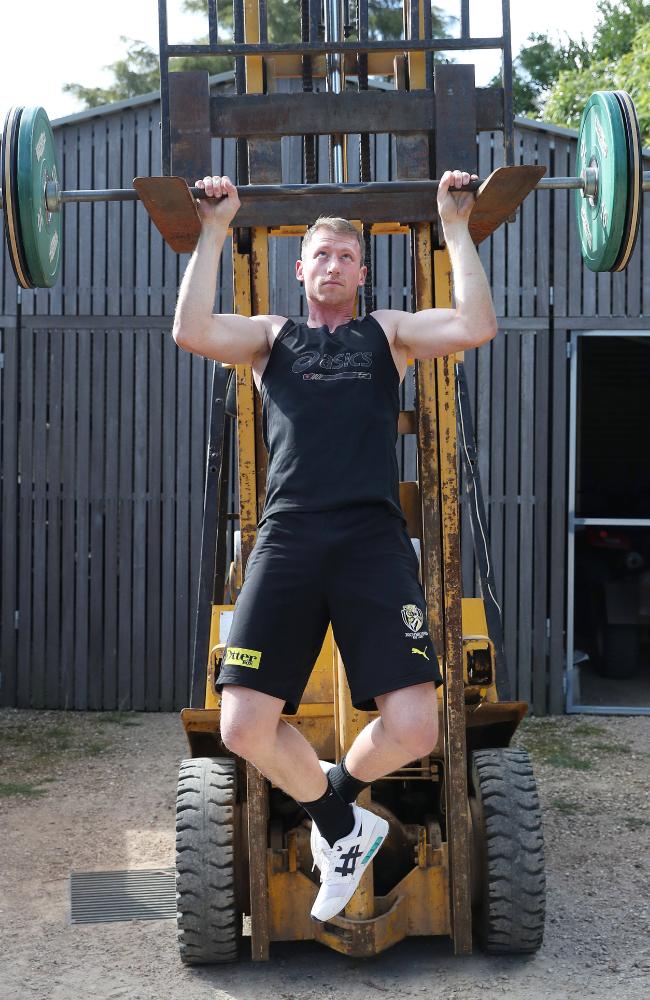 Grimes uses the barbell to do pull-ups as he works to maintain his strength during the enforced layoff.