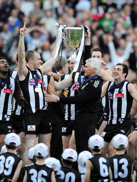 The Pies lift the cup after the game.