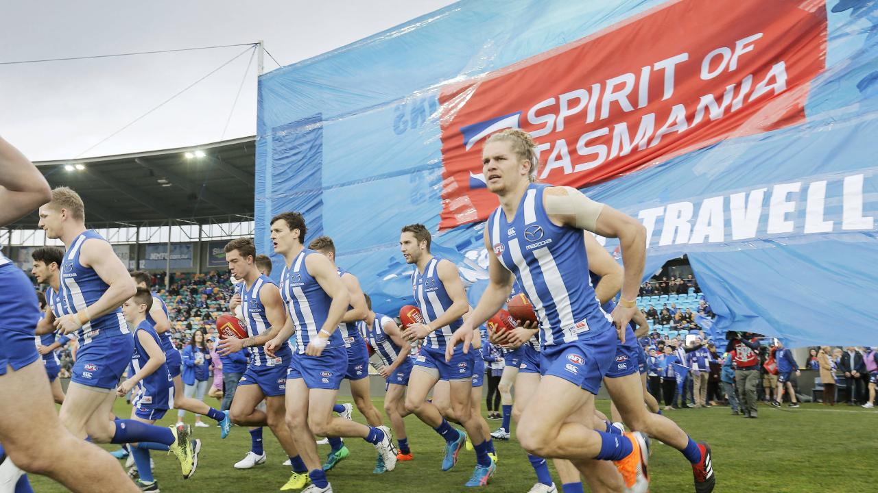 North Melbourne players run through their banner at a North Melbourne versus West Coast AFL match at Blundstone Arena. Picture: MATHEW FARRELL