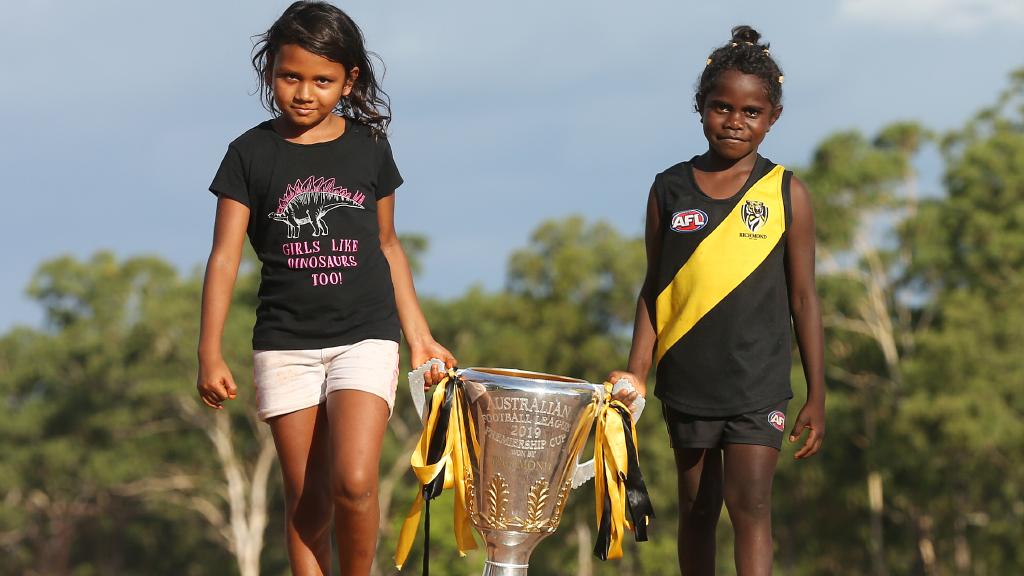 Daniels younger sister Hayley (left) and Paia Manmurulu carry the 2019 Cup into town. Picture: Michael Klein