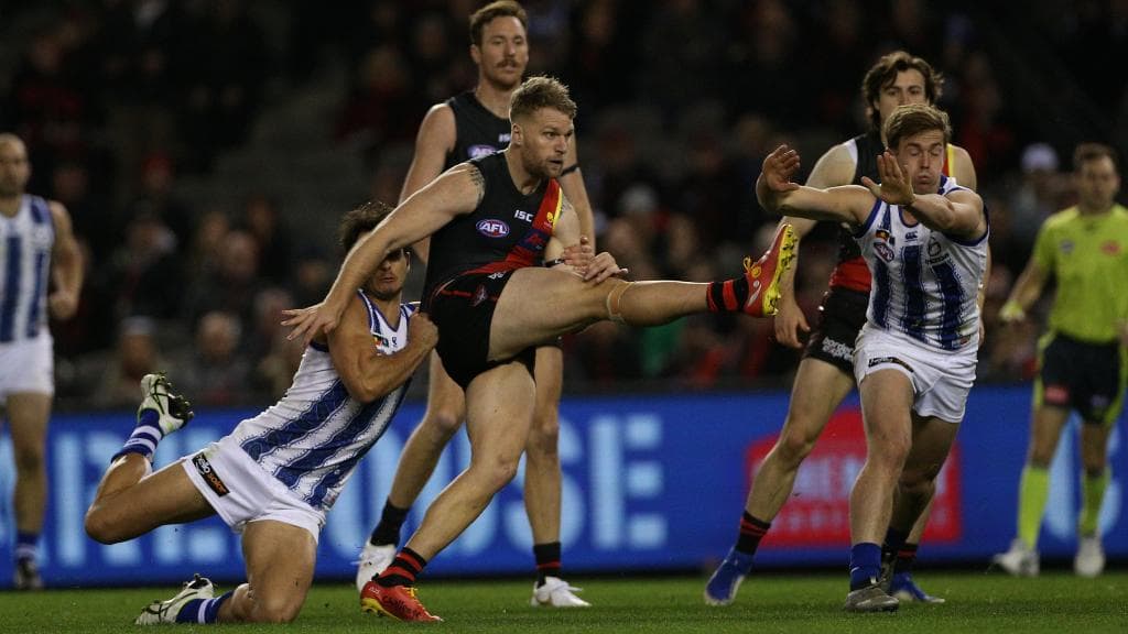 North Melbourne’s Robbie Tarrant drags down Essendon’s Jake Stringer in a tackle on Saturday. Picture: AAP Image/Hamish Blair