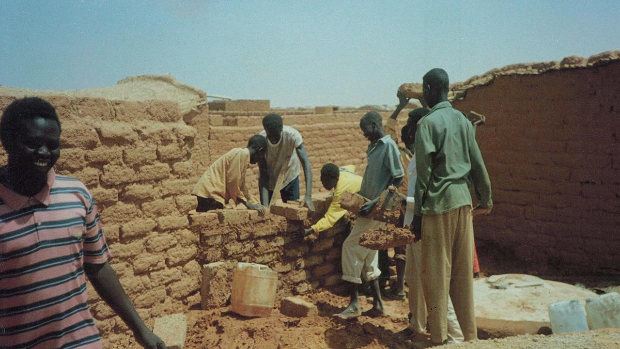 Daw helping to build a school, using mud bricks and sand mixed with glue, when he was younger. Picture: Supplied