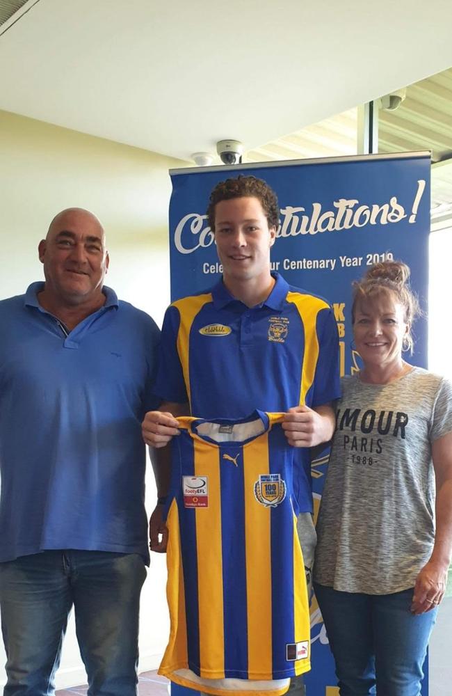 Flanked by parents Bruce and Melissa, Liam Scott receives his senior Noble Park stripes.
