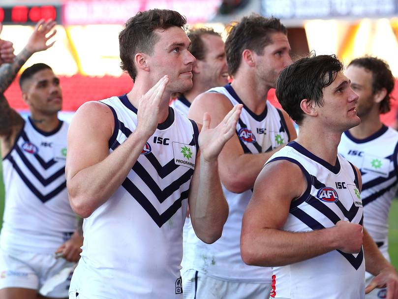 Blake Acres and his Dockers team mates celebrate winning the round 17 AFL match between the North Melbourne Kangaroos and the Fremantle Dockers.