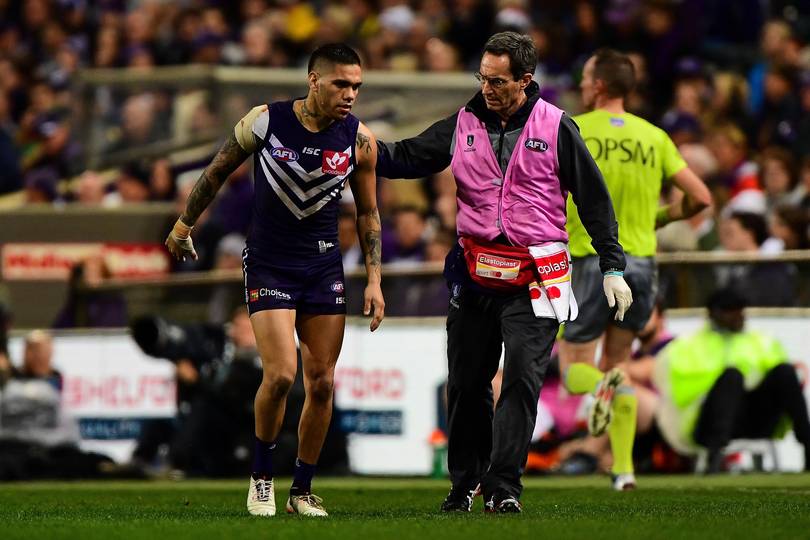 Michael Walters limps off the field helped by Dr Jeff Boyle.