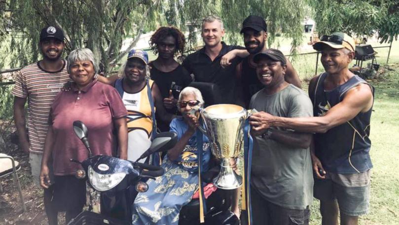 Helena Rioli, centre, poses with grandson Willie Jnr, family, West Coast coach Adam Simpson and the 2018 premiership cup.