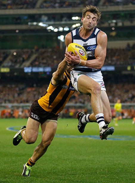 corey-enright-of-the-cats-marks-ahead-of-paul-puopolo-of-the-hawks-picture-id601054760