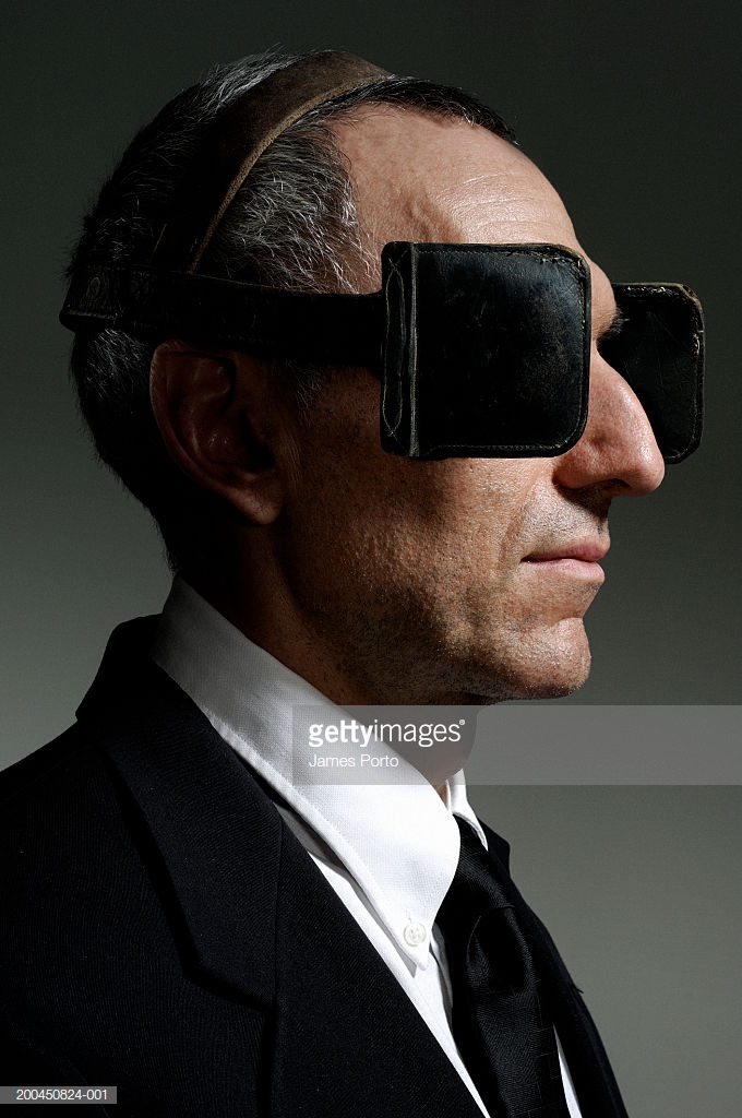 mature-businessman-wearing-blinkers-closeup-side-view-picture-id200450824-001