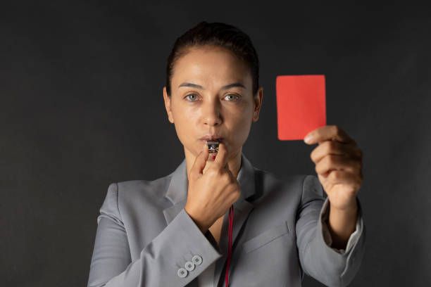 business-woman-holding-red-card-and-blowing-a-whistle-picture-id1167595391