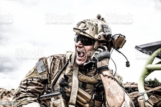 soldier-communicating-with-command-during-battle-picture-id981641916