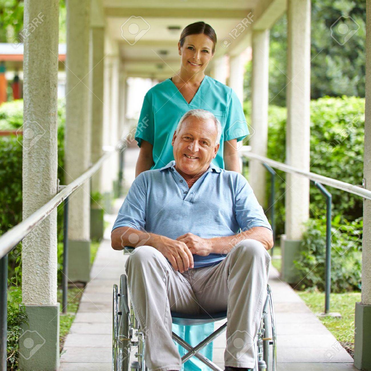 17853940-Happy-nurse-pushing-wheelchair-with-senior-man-in-hospital-garden-Stock-Photo.jpg