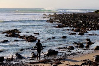 Coastal life: Ballantyne surfs, and also works at the port.