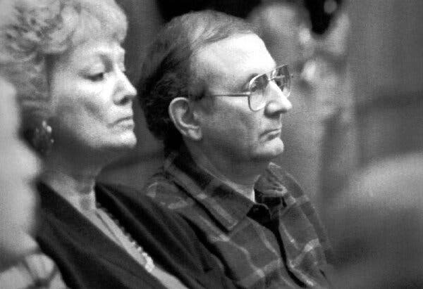 A black-and-white photo of Jeffrey Dahmer’s  father and stepmother in a courtroom, from a side view.