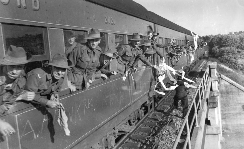 StateLibQld_1_187623_Soldiers_waving_from_the_window_of_a_train_in_Brisbane%2C_Queensland%2C_1940.jpg