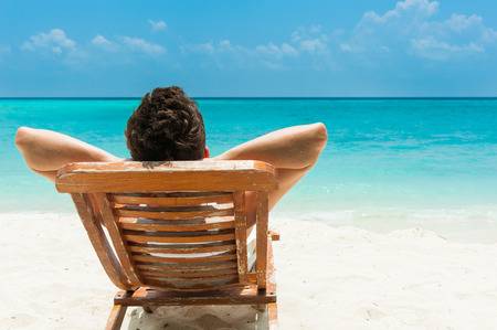 32406216-man-relaxing-on-beach-ocean-view-maldives-island.jpg